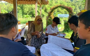 Perajin batik Giriloyo membimbing anak-anak mencanting di pendopo Wukirsari, Imogiri, Bantul
